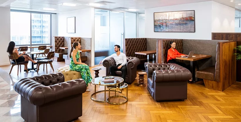 Clients working and networking in Canary Wharf coworking space featuring 5-star interiors, hot desks, and collaborative booths.